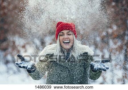 Happy young woman playing in snow View Large Photo Image Stock Photo - Happy young woman playing in snow. Fotosearch