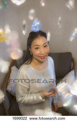 High angle portrait of smiling woman standing in living room at home View Large Photo Image Stock Image - High angle portrait of smiling woman standing in living room at home. Fotosearch