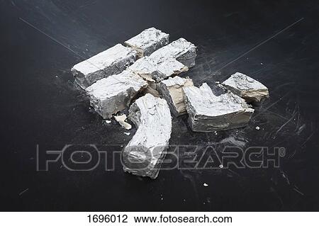 Stock Image - High angle view of broken concrete New Taiwan dollar symbol on table. Fotosearch