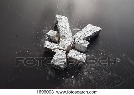 Stock Image - High angle view of broken Yen sign on black table. Fotosearch