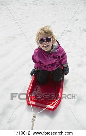 High angle view of cheerful boy tobogganing on snow covered field View Large Photo Image Stock Image - High angle view of cheerful boy tobogganing on snow covered field. Fotosearch