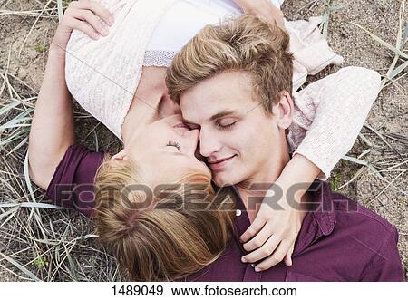 High angle view of couple while lying on field View Large Photo Image Stock Photo - High angle view of couple while lying on field. Fotosearch