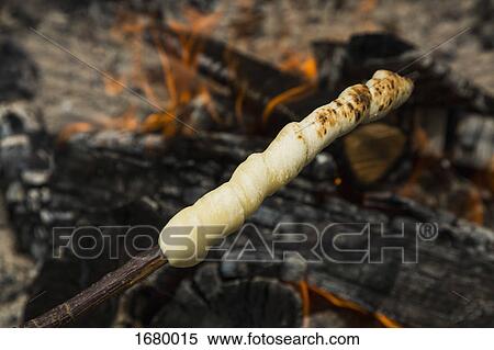 High angle view of dough on wooden skewer over fire View Large Photo Image Stock Photography - High angle view of dough on wooden skewer over fire. Fotosearch