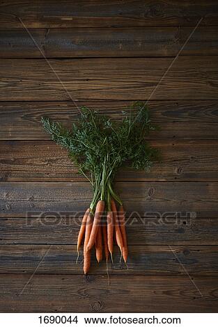Picture - High angle view of fresh carrots on wooden table. Fotosearch