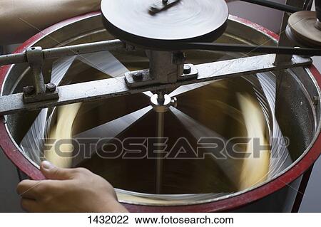 Stock Image - High angle view of honey being separated in machinery at industry. Fotosearch