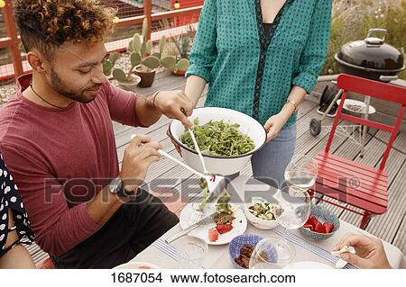 High angle view of man serving salad in plate at patio View Large Photo Image Picture - High angle view of man serving salad in plate at patio. Fotosearch