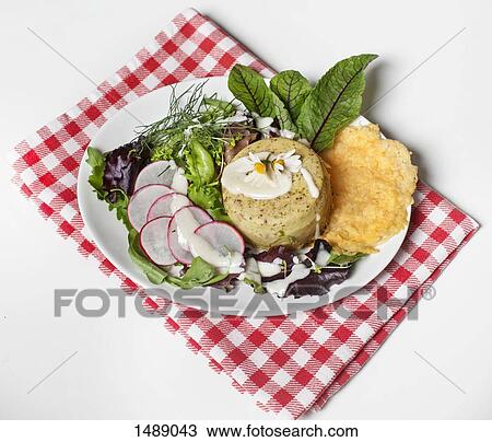 Stock Image - High angle view of pate and salad served in plate over white background. Fotosearch