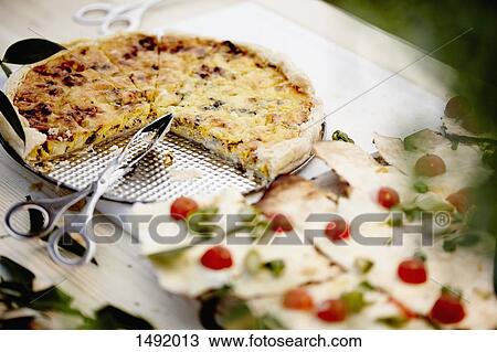 Stock Image - High angle view of pizza and scissors served on table. Fotosearch