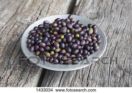 High angle view of purple olives in plate on wood View Large Photo Image Picture - High angle view of purple olives in plate on wood. Fotosearch