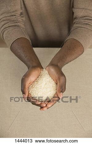 High angle view of rice in cupped hands at table View Large Photo Image Stock Image - High angle view of rice in cupped hands at table. Fotosearch