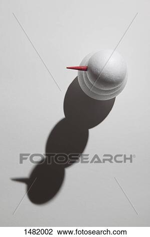 Stock Image - High angle view of snowman and its shadow on white background. Fotosearch