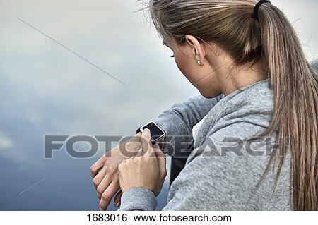 High angle view of woman using smart watch against lake View Large Photo Image Stock Photograph - High angle view of woman using smart watch against lake. Fotosearch