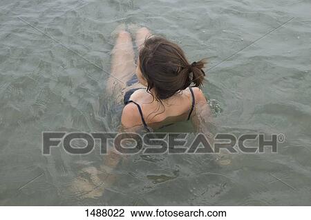 High angle view of young woman relaxing in water View Large Photo Image Stock Image - High angle view of young woman relaxing in water. Fotosearch
