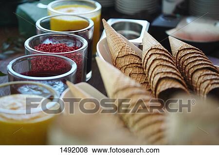 Ice cream cones and various flavored syrups at store View Large Photo Image Stock Photo - Ice cream cones and various flavored syrups at store. Fotosearch