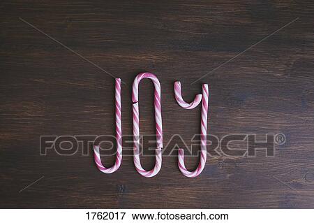 JOY written with candy canes on wooden background View Large Photo Image Stock Photo - JOY written with candy canes on wooden background. Fotosearch