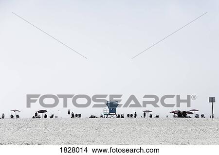 Lifeguard tower and people relaxing under umbrellas on sunny beach, San Diego, California, USA View Large Photo Image Picture - Lifeguard tower and people relaxing under umbrellas on sunny beach, San Diego, California, USA. Fotosearch