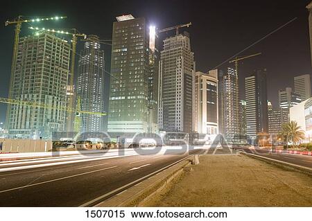 Light trails on city street against illuminated buildings at night View Large Photo Image Stock Photography - Light trails on city street against illuminated buildings at night. Fotosearch