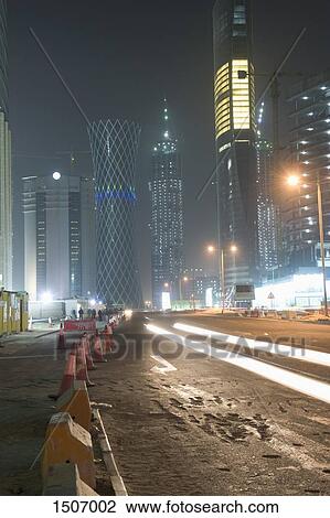 Light trails on street against illuminated buildings in city at night View Large Photo Image Stock Image - Light trails on street against illuminated buildings in city at night. Fotosearch