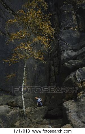 Low angle view of boy hiking against rock formation, Elbe Sandstone Mountains, Germany View Large Photo Image Stock Image - Low angle view of boy hiking against rock formation, Elbe Sandstone Mountains, Germany. Fotosearch