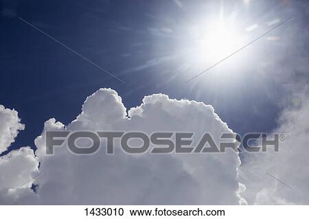 Low angle view of bright sun in cloudy sky View Large Photo Image Stock Image - Low angle view of bright sun in cloudy sky. Fotosearch