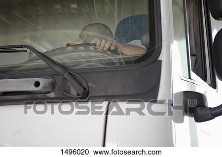 Low angle view of driver sleeping in truck seen through windshield View Large Photo Image Stock Image - Low angle view of driver sleeping in truck seen through windshield. Fotosearch
