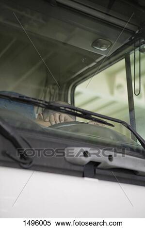 Low angle view of driver sleeping in truck as seen through windshield View Large Photo Image Stock Photography - Low angle view of driver sleeping in truck as seen through windshield. Fotosearch