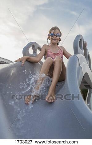 Low angle view of girl enjoying water slide against sky View Large Photo Image Stock Photo - Low angle view of girl enjoying water slide against sky. Fotosearch