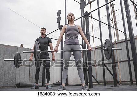 Low angle view of male and female athlete lifting barbells during crossfit training View Large Photo Image Stock Photo - Low angle view of male and female athlete lifting barbells during crossfit training. Fotosearch