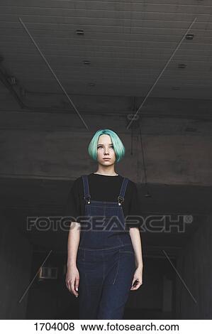 Stock Photo - Low angle view of teenage girl standing in basement. Fotosearch