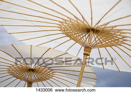 Stock Photograph - Low angle view of traditional parasols against sky. Fotosearch
