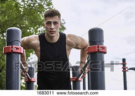 Low angle view of young male athlete exercising on parallel bars against sky View Large Photo Image Stock Image - Low angle view of young male athlete exercising on parallel bars against sky. Fotosearch