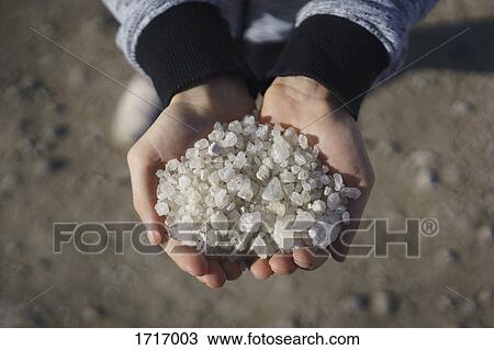 Stock Image - Low section of person holding salt. Fotosearch