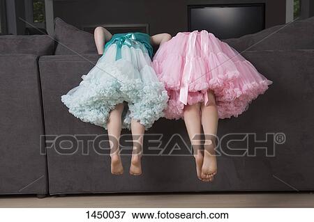 Low section of sibling bending on sofa's back at home View Large Photo Image Stock Photo - Low section of sibling bending on sofa's back at home. Fotosearch