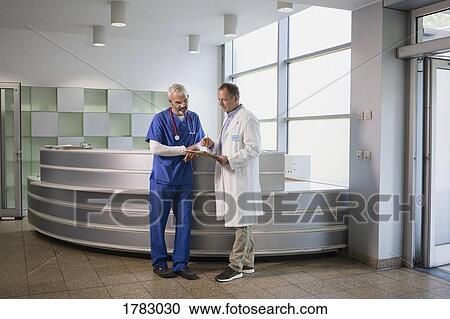 Male doctors discussing medical record in hospital View Large Photo Image Stock Image - Male doctors discussing medical record in hospital. Fotosearch