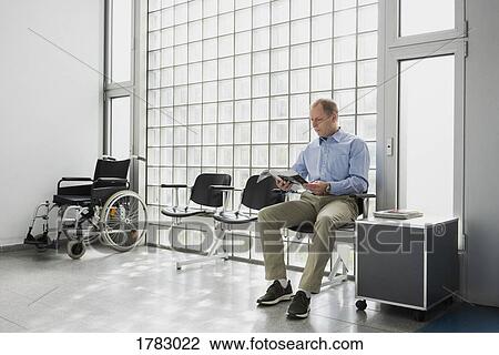Male patient waiting, reading magazine in clinic waiting room View Large Photo Image Stock Image - Male patient waiting, reading magazine in clinic waiting room. Fotosearch