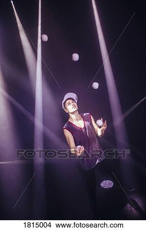 Picture - Male performer juggling balls on stage. Fotosearch
