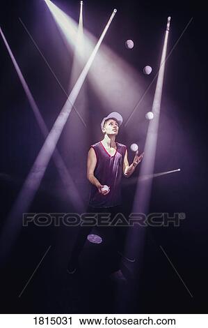 Stock Image - Male performer juggling on stage. Fotosearch
