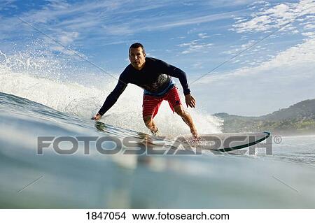 Male surfer riding ocean wave View Large Photo Image Picture - Male surfer riding ocean wave. Fotosearch