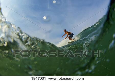 Male surfer riding ocean wave View Large Photo Image Stock Image - Male surfer riding ocean wave. Fotosearch