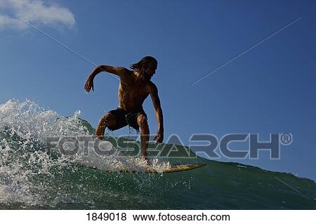 Male surfer riding ocean wave View Large Photo Image Stock Photo - Male surfer riding ocean wave. Fotosearch