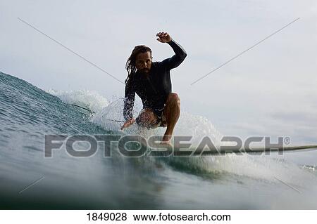 Male surfer riding ocean wave View Large Photo Image Stock Photo - Male surfer riding ocean wave. Fotosearch