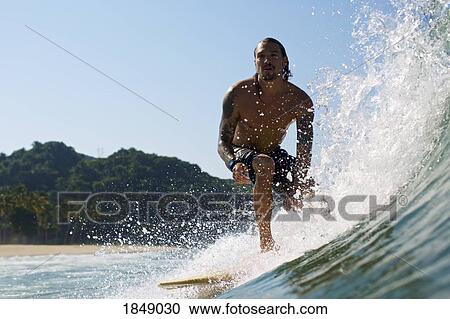 Male surfer riding sunny ocean wave View Large Photo Image Stock Image - Male surfer riding sunny ocean wave. Fotosearch