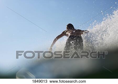 Stock Image - Male surfer riding wave. Fotosearch