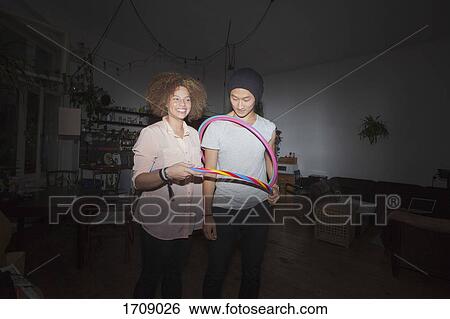 Man and woman holding plastic hoops while standing at home View Large Photo Image Stock Photograph - Man and woman holding plastic hoops while standing at home. Fotosearch