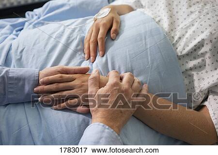 Man comforting female patient recovering in hospital bed View Large Photo Image Stock Photo - Man comforting female patient recovering in hospital bed. Fotosearch