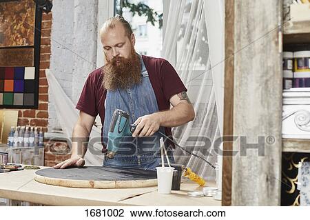 Man drying paint on wood with dryer at workshop View Large Photo Image Stock Image - Man drying paint on wood with dryer at workshop. Fotosearch