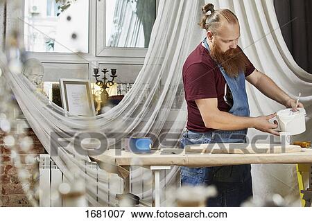 Man pouring paint in container on workbench at workshop View Large Photo Image Stock Photo - Man pouring paint in container on workbench at workshop. Fotosearch