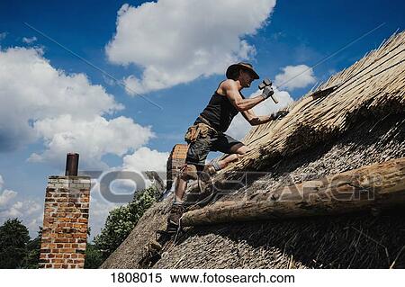 Man repairing thatch roof on sunny house View Large Photo Image Stock Photography - Man repairing thatch roof on sunny house. Fotosearch