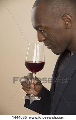 Man smelling red wine against colored background View Large Photo Image Stock Photography - Man smelling red wine against colored background. Fotosearch
