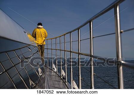 Man standing on deck of boat on sunny ocean View Large Photo Image Stock Image - Man standing on deck of boat on sunny ocean. Fotosearch